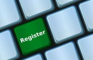 Een keyboard met een opvallende groene knop met de witte tekst "Register", omringd door blanco lichtblauwe toetsen.