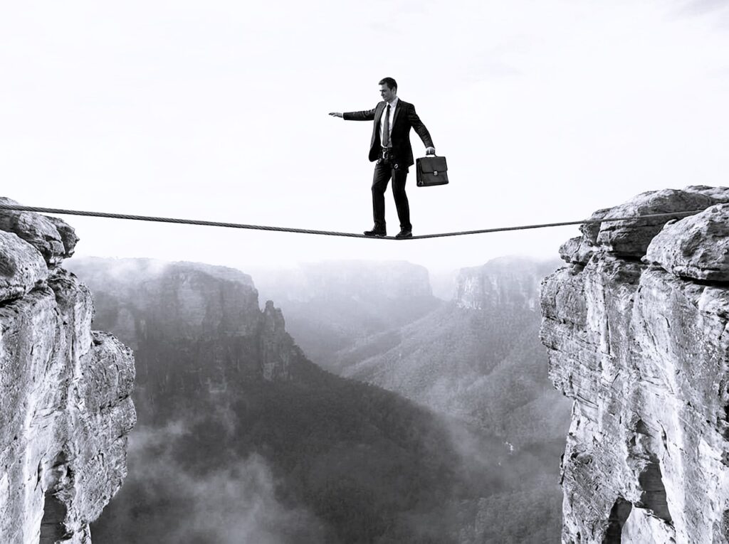 Zakenman balanceert op een strakgespannen koord boven een diepe afgrond. Conceptueel beeld voor het nemen van grote risico's en het zoeken naar financiële of juridische balans.