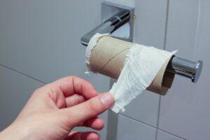 Een hand reikt naar het toiletpapier, maar het is op.